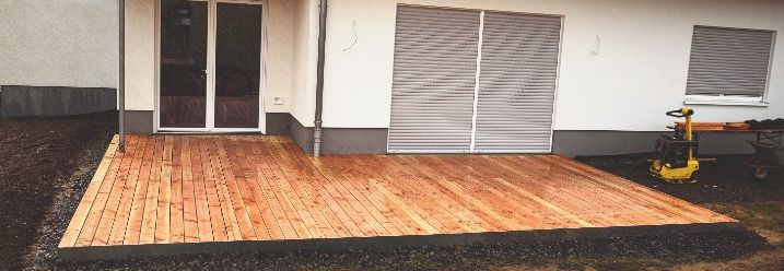 Holzterrasse vor Hauswand